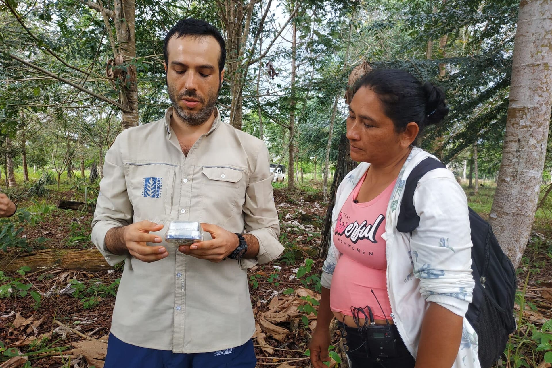 investigador con ciudadana revisando cámara trampa